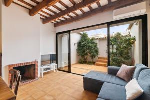 a living room with a couch and a fireplace at Casa con patio, piedra y luz natural in Sant Pere de Ribes