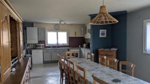 a kitchen with a table and chairs and a table and a tableablish at Le temps des vacances in Vaudricourt +18 photos