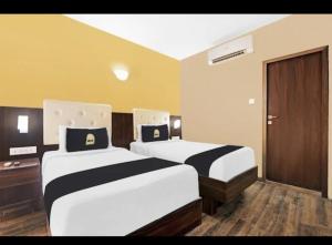 a hotel room with two beds in a room at Hotel The Pal Palace in Nagpur