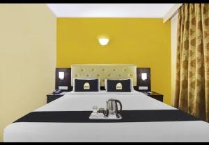 a bedroom with a large white bed with yellow walls at Hotel The Pal Palace in Nagpur