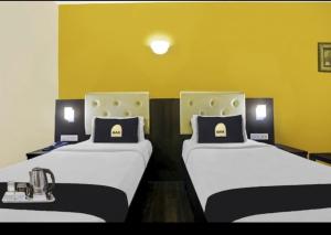 two beds sitting next to each other in a room at Hotel The Pal Palace in Nagpur +1 photo
