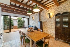 a kitchen and dining room with a wooden table and chairs at Casa con patio, piedra y luz natural in Sant Pere de Ribes