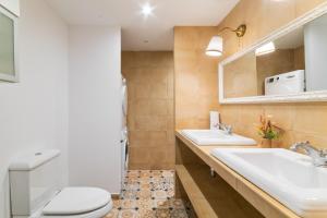 a bathroom with two sinks and a toilet and a mirror at Casa con patio, piedra y luz natural in Sant Pere de Ribes +34 photos