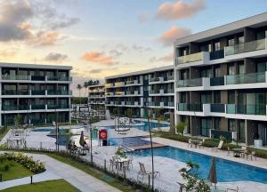 an apartment complex with a swimming pool and a resort at Makia Beach Experience Muro Alto Porto de Galinhas in Ipojuca