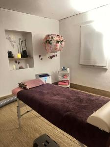 a bedroom with a large bed with a purple blanket at Cozy spa sun set in Trois Bassins