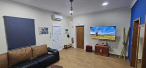 a living room with a couch and a large screen at Santa Barbara Beach hotspot in Ribeira Grande