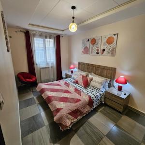 a bedroom with a bed and two tables with lamps at Joli F3 in Dar el Beïda