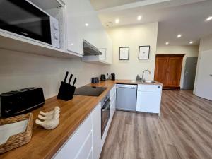 a kitchen with white appliances and a wooden floor at Duplex Cosy proche parlement européen et Strasbourg in Schiltigheim +12 photos