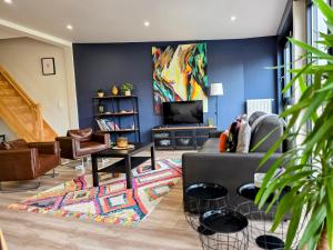 a living room with a couch and a tv at Duplex Cosy proche parlement européen et Strasbourg in Schiltigheim