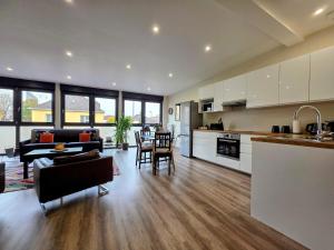 a kitchen and living room with a table and chairs at Duplex Cosy proche parlement européen et Strasbourg in Schiltigheim