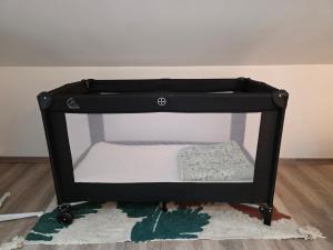 a small black shelf with a mattress on a rug at Duplex Cosy proche parlement européen et Strasbourg in Schiltigheim