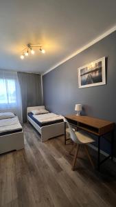 a room with two beds and a desk and a desk at Jugendgästehaus Lichterfelde JuLi in Berlin +4 photos