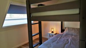 a bedroom with a bunk bed and a window at Vakantiewoning d'Hoppe in Flobecq