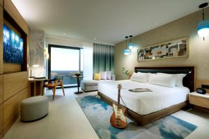 a hotel room with a bed and a guitar in it at Hard Rock Hotel Malta in St. Julianʼs