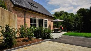 two people sitting at a table under an umbrella at Vakantiewoning d'Hoppe in Flobecq
