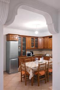 a kitchen with a table and a stainless steel refrigerator at EUREKA in Vlorë