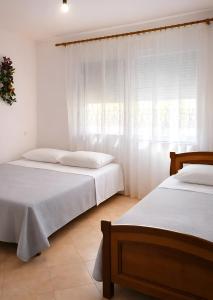 a bedroom with two beds and a window at EUREKA in Vlorë