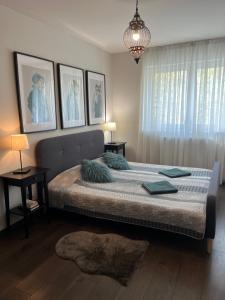 a bedroom with a large bed and a chandelier at Thermal Forest Apartment in Kiskunhalas