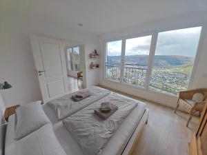 a white bedroom with a bed and a large window at Moselsteig Lodge in Starkenburg