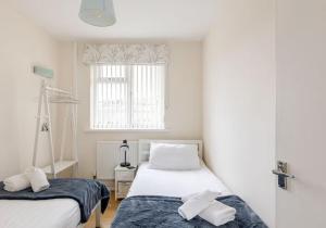 a bedroom with two beds and a window at Highview, extended 2 bedroom house, with view, near coast path in The Mumbles