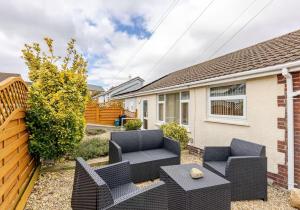 a backyard with black furniture and a house at Highview, extended 2 bedroom house, with view, near coast path in The Mumbles