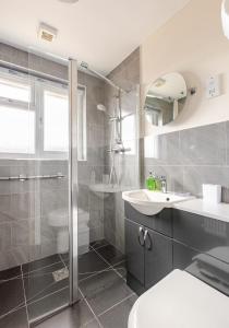 a bathroom with a shower and a sink and a toilet at Highview, extended 2 bedroom house, with view, near coast path in The Mumbles +22 photos