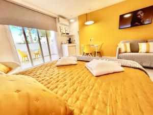 a bedroom with a large yellow bed with two pillows on it at Modern Studio with Pool & Terrace Playa de las Américas, Tenerife in Playa de las Americas +50 photos