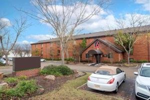 two cars parked in front of a brick building at Studio 6 Suites Jackson Ridgeland MS in Ridgeland