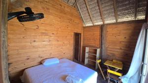 a bedroom with a bed in a wooden room at Chalé mirante in Tutóia