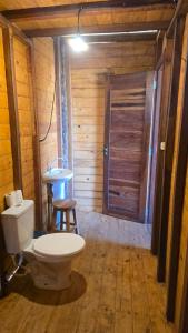 a bathroom with a toilet and a table and a door at Chalé mirante in Tutóia