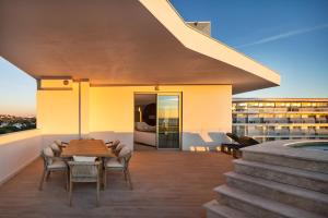 a patio with a table and chairs on a building at Castelo Suites Hotel in Albufeira