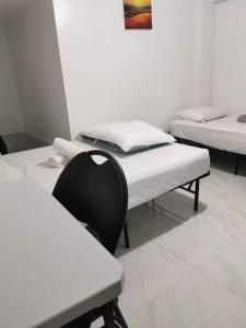 a room with two beds and a chair in it at 586 Hotel in Toronto
