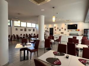 a restaurant with tables and chairs and a kitchen at Master Hotel in Cadelbosco di Sopra