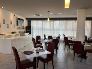 a dining room with tables and chairs and a kitchen at Master Hotel in Cadelbosco di Sopra +16 photos