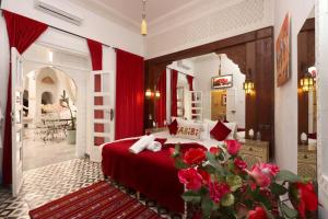 a bedroom with a bed with red sheets and a mirror at Riad Morocco Sky in Marrakesh