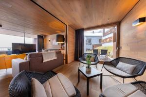 a living room with two couches and a television at Smaragdresort Chalet Bergblick in Bramberg am Wildkogel