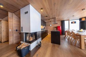 a living room with a fireplace and a dining room at Smaragdresort Chalet Bergblick in Bramberg am Wildkogel
