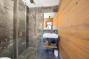 a bathroom with a sink and a shower at Smaragdresort Chalet Bergblick in Bramberg am Wildkogel +33 photos