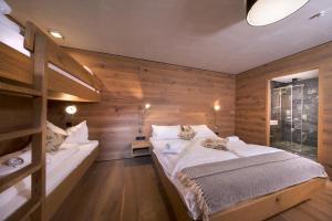 a bedroom with wooden walls and a large bed at Smaragdresort Chalet Bergblick in Bramberg am Wildkogel