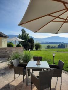 a patio with a table and chairs and an umbrella at Pension Kreuzinger, 5310 Tiefgraben in Mondsee