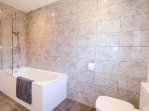 a bathroom with a tub and a toilet and a sink at Snowdrop Cottage in Maidstone +25 photos