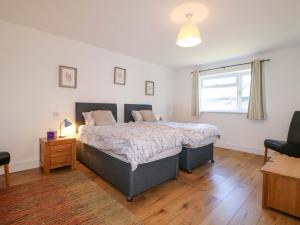 a bedroom with a large bed and a window at Snowdrop Cottage in Maidstone