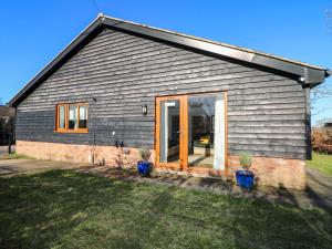 a small house with a large sliding glass door at Snowdrop Cottage in Maidstone
