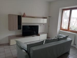 a living room with a couch and a flat screen tv at Casa Mirabella in Sirolo