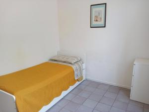 a small bedroom with a bed with a yellow blanket at Casa Mirabella in Sirolo
