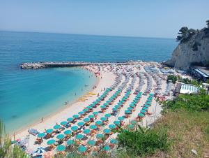 a beach with many umbrellas and people on it at Casa Mirabella in Sirolo
