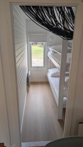a room with two bunk beds and a window at Henneby Camping - hytter in Henne Strand