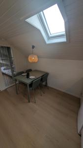 a table and chairs in a room with a skylight at Henneby Camping - hytter in Henne Strand