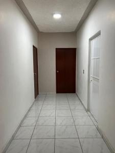an empty hallway with a door and a tile floor at Casa Ale in Brisas de Zicatela
