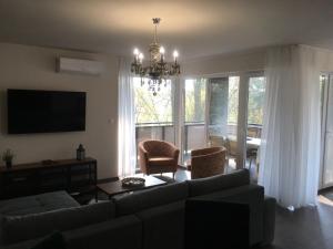 a living room with a couch and a chandelier at Thermal Forest Apartment in Kiskunhalas
